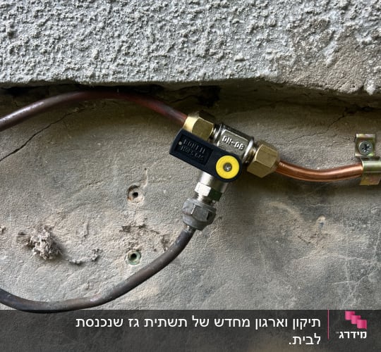 שסתום גז עם צינור נחושת על קיר בטון